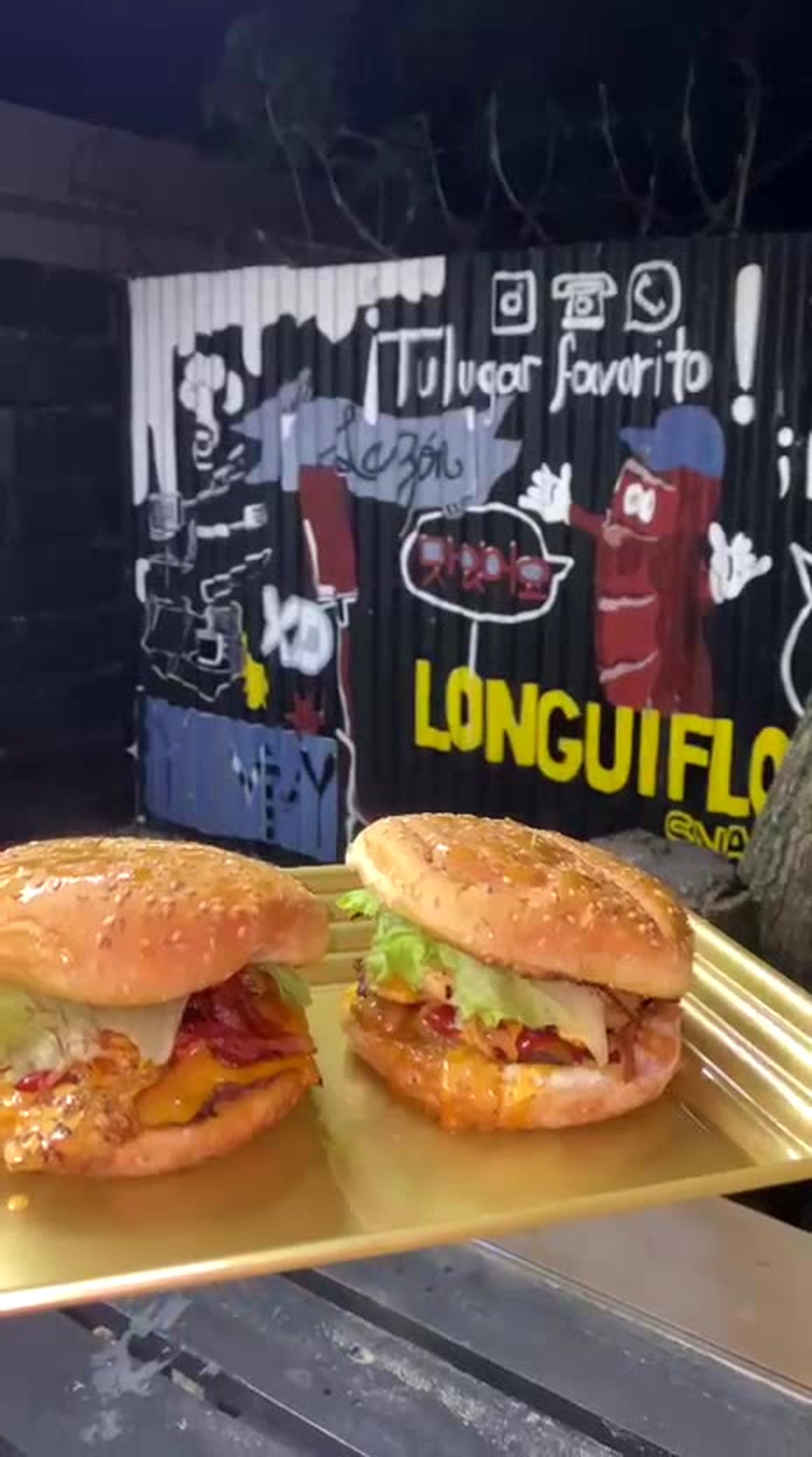Longui Burgers frente al mural de Longuiflow